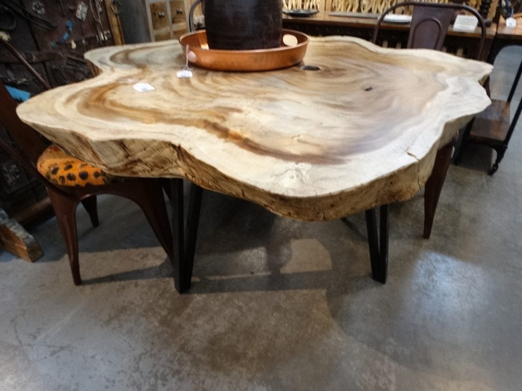 Wooden Dining Table features black metal V legs and a live edge top.