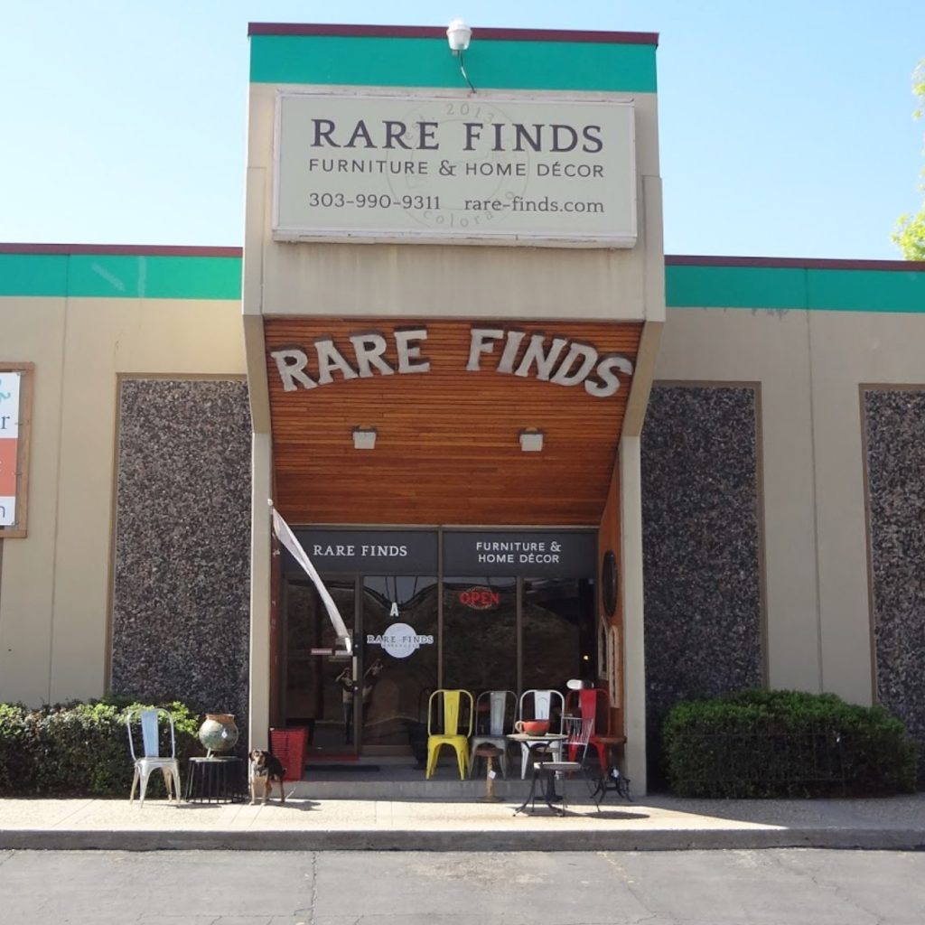 Front of Rare Finds Furniture & Home Décor shop with colorful chairs arranged outside the entrance.